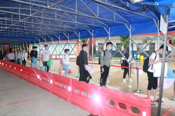 1590048029222001.jpeg 学生在入校通道有序排队,准备进行二次测温登记消毒进入学校.JPG